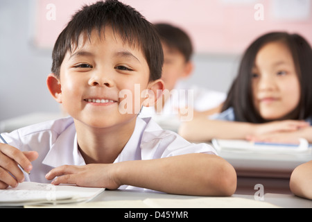 Groupe d'étudiants travaillant à un bureau en classe de l'école chinoise Banque D'Images