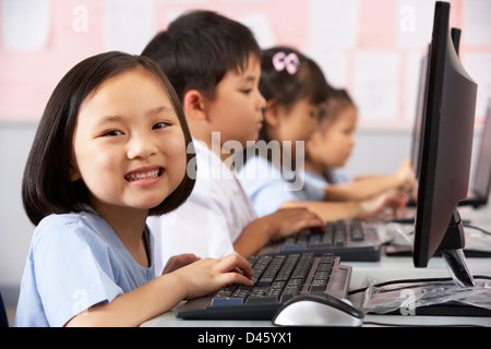 Élève de sexe féminin à l'aide clavier durant la classe d'informatique en classe de l'école chinoise Banque D'Images