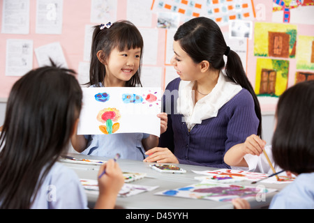 Aider les élèves de l'enseignant au cours de la classe d'Art en classe de l'école chinoise Banque D'Images