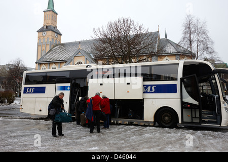 Navette aéroport sas de déchargement entraîneur de touristes en hiver froid Tromso Tromsø Norvège europe Banque D'Images