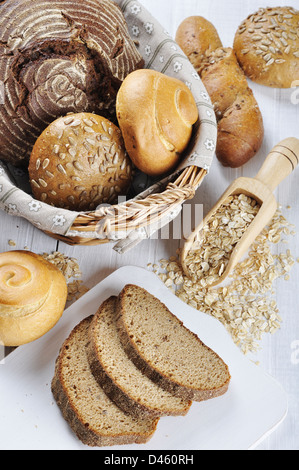 La composition avec pain et petits pains dans panier en osier blanc sur fond de bois Banque D'Images