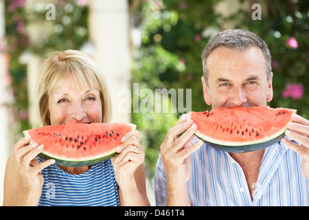 Mère et fille adultes bénéficiant des tranches de melon d'eau Banque D'Images