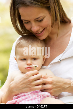 Mother Sitting avec bébé fille dans domaine de fleurs d'été Banque D'Images