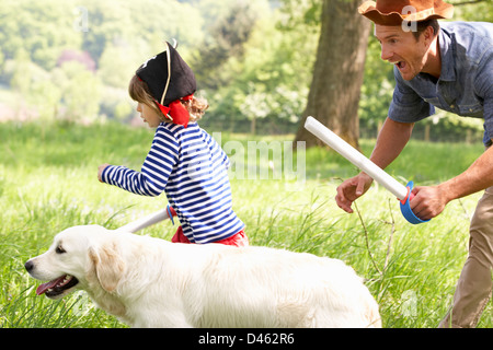 Père jouer Jeu d'aventure passionnant avec le Fils et le chien dans le champ d'été Banque D'Images