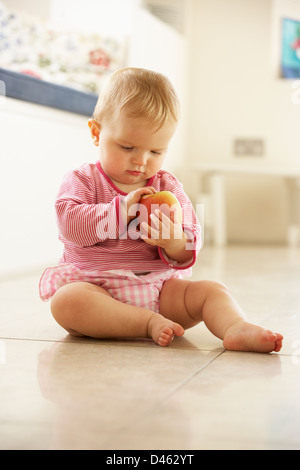 Baby Girl Sitting on Floor à chez Apple Banque D'Images