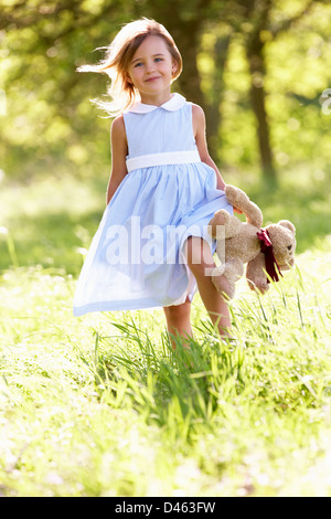 Jeune fille marche à travers champ d'été Réalisation Ours Banque D'Images