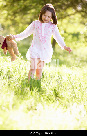 Jeune fille marche à travers champ d'été Réalisation Ours Banque D'Images