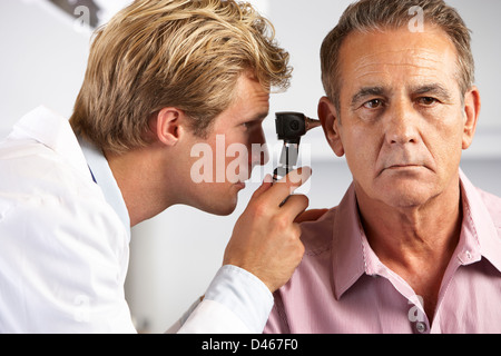 Doctor Examining Patient's Ears Banque D'Images