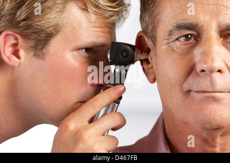 Doctor Examining Patient's Ears Banque D'Images