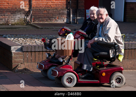 Couple retraités assis sur un fauteuil motorisé Banque D'Images