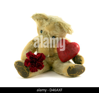 Old vintage teddy avec Red Carnation et coeur sur fond blanc. Banque D'Images