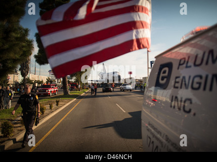 La navette spatiale Endeavour traverse Los Angeles, en Californie, avec le drapeau américain exposé. Le transport de la navette fait partie de son dernier voyage vers le California Science Center. Banque D'Images
