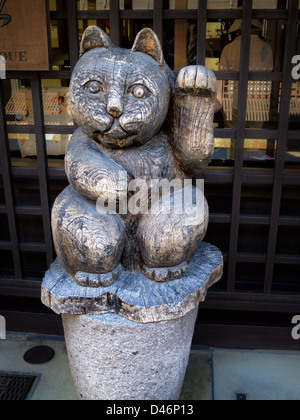 Maneki neko en bois ('signe cat'), courant à l'extérieur des magasins et à l'intérieur d'entreprises au Japon. Il apporte la bonne chance et prospérité. Banque D'Images