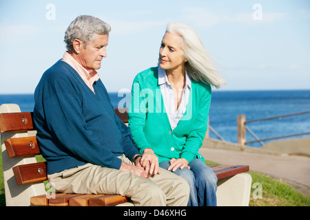 Senior Woman réconfortant déprimé mari assis sur un banc Banque D'Images