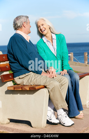 Senior Couple Sitting on Bench Par Mer Banque D'Images
