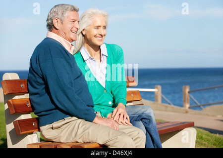 Senior Couple Sitting on Bench Par Mer Banque D'Images