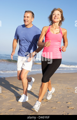 Senior Couple Exercising On Beach Banque D'Images