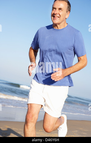 Senior Man Exercising On Beach Banque D'Images