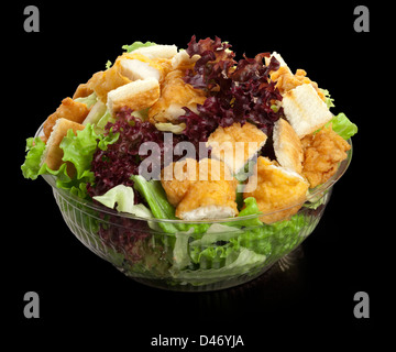 Salade avec du poulet et de la laitue fraîche sur fond noir dans un bol transparent Banque D'Images