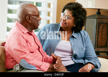 Happy Senior Couple Sitting on Sofa At Home Banque D'Images