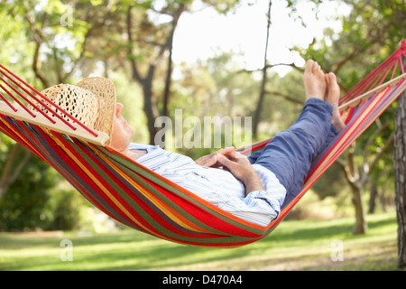 Senior Man Relaxing In Hammock Banque D'Images