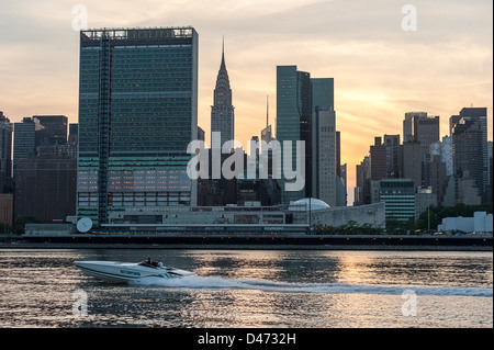 Silhouette de New York avec l'Organisation des Nations Unies et le Chrysler Building au-dessus de la rivière de l'Est au coucher du soleil. Banque D'Images