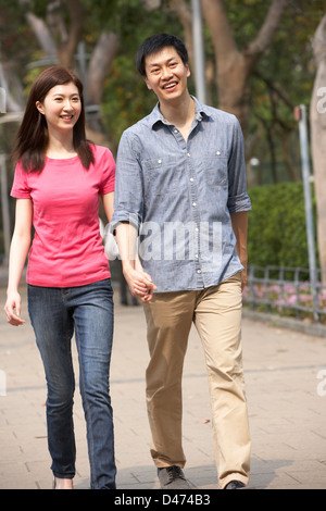 Jeune Chinois Couple Walking in Park Banque D'Images