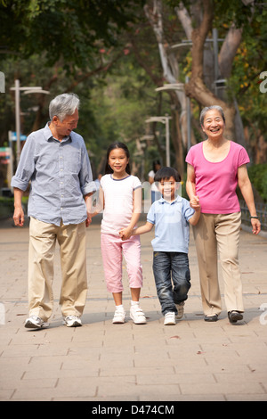 Les grands-parents chinois marcher dans parc avec petits-enfants Banque D'Images