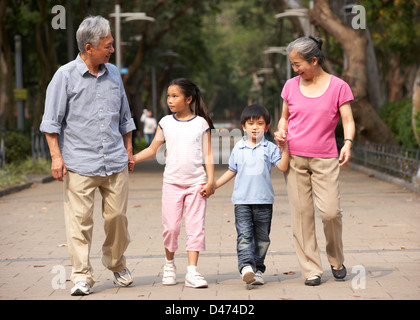 Les grands-parents chinois marcher dans parc avec petits-enfants Banque D'Images