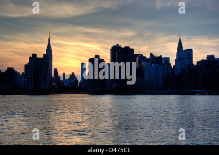 Silhouette de New York avec l'Empire State et le Chrysler Building au-dessus de la rivière de l'Est après le coucher du soleil . Banque D'Images
