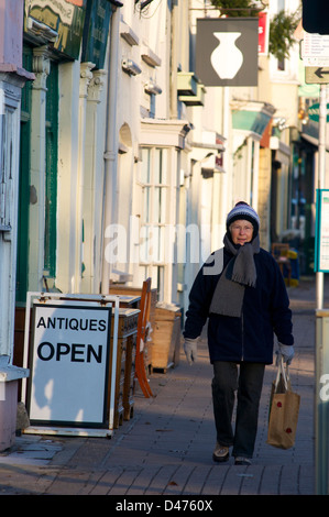 Lady shopping à l'extérieur d'un magasin d'antiquités dans l'hiver sur la rue principale. Honiton, Devon, UK Banque D'Images