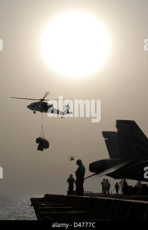 Un MH-60S Sea Hawk transporte des palettes de fournitures de l'USS Ronald Reagan Banque D'Images