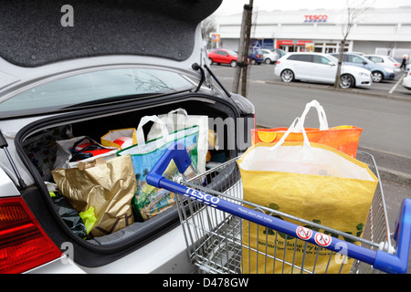 Les sacs dans un Tesco shopping trolley et Tesco dans un parking, Ecosse, Royaume-Uni Banque D'Images