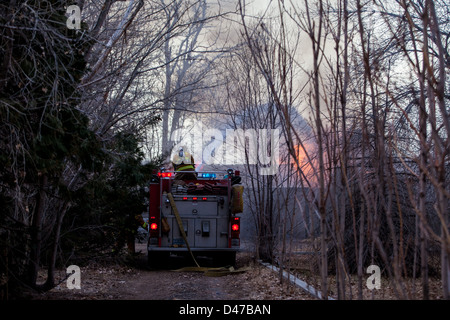 Un pompier utilise un canon pour mettre de l'eau sur l'incendie d'une maison en Fernley Nevada Banque D'Images