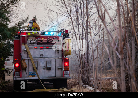 Un pompier utilise un canon pour mettre de l'eau sur l'incendie d'une maison en Fernley Nevada Banque D'Images