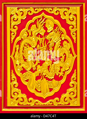Golden dragon chinois bois Sculpture sur fond rouge. Banque D'Images