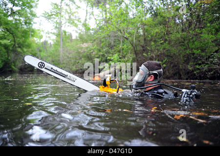 Un membre de l'équipe de construction sous-marine au large de leurs mains en préparation scie hydraulique pour quitter la rivière sur le terrain lors d'un exercice d'entraînement. Banque D'Images