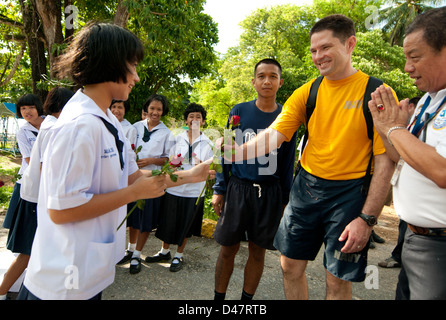 Un aumônier de commandement reçoit une fleur d'un étudiant de l'école Ban Aonamber au cours d'un projet de service communautaire avec la Marine royale thaïlandaise. Banque D'Images