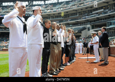 Plusieurs membres du service et de l'entrée retardée programme membres récitent le serment d'engagement avec le commandant du groupe aéronaval 10, avant un match de baseball de ligue majeure durant la Fleet Week de New York 2012. Banque D'Images