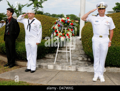 Le XO de la base navale de Norfolk est à l'attention et salue pendant l'hymne national lors d'une cérémonie de pose de couronnes de la bataille de Midway à la base navale de Norfolk. Banque D'Images