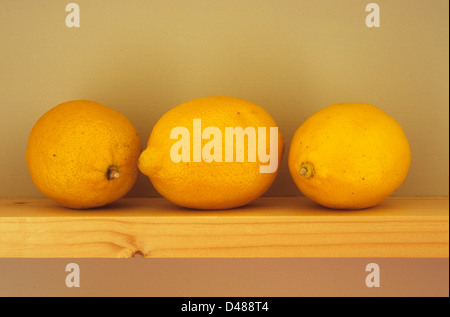 Vue de la hauteur des yeux de trois citrons sur étagère en bois étroit Banque D'Images