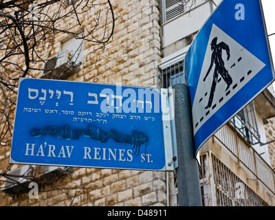 Une inscription trilingue portant le nom de Ha'Rav Reines Street a été vandalisé, ruinant l'inscription en arabe, dans le cadre d'une campagne raciste anti-arabe, généralisée dans l'Kirayt Moshe quartier. Jérusalem, Israël. 8-mars-2013. Des signes de racisme anti-arabes sont évidentes comme un grand nombre de plaques de rue ont été tendentiously vandalisé dans la sioniste-religieux moderne près de Kiryat Moshe, ruinant délibérément trilingue arabe inscription sur des plaques de rue. Banque D'Images