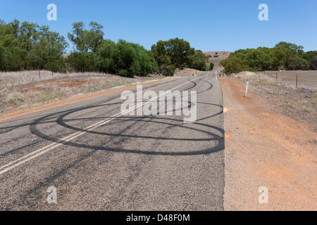 Burn out car les traces de pneu sur la route de roues spiinning, Murchison Australie Occidentale Banque D'Images