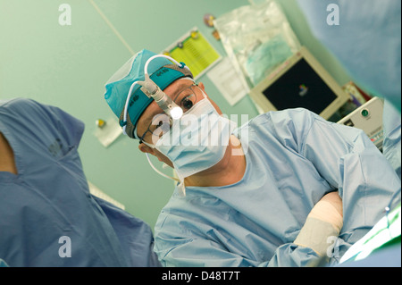 Un chirurgien porte une lampe de tête micro qu'il utilise dans son travail. Banque D'Images