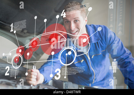Voiture de mécanicien réparer tandis que l'interface de consultation Banque D'Images