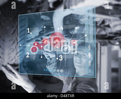 Voiture de mécanicien réparer tout en regardant futuristic interface Banque D'Images