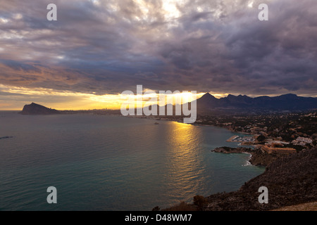 La baie d'Altea au coucher du soleil, avec le soleil montrant à travers les nuages et les montagnes, Altea, Province d'Alicante, Costa Blanca, Espagne Banque D'Images