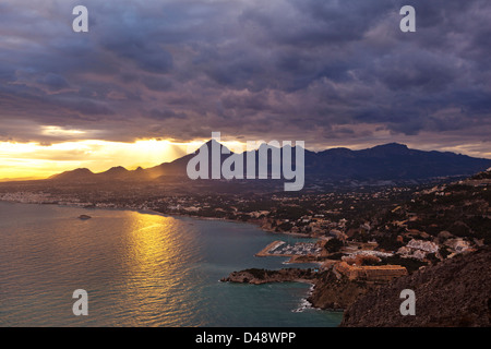 La baie d'Altea au coucher du soleil, avec le soleil montrant à travers les nuages et les montagnes, Altea, Province d'Alicante, Costa Blanca, Espagne Banque D'Images