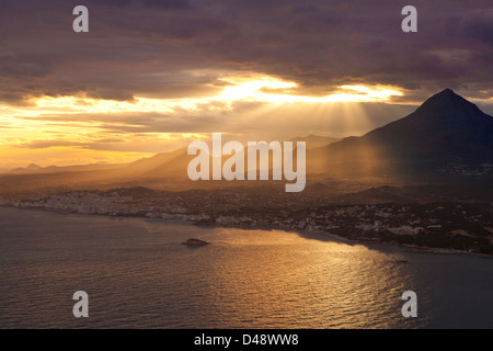 La baie d'Altea au coucher du soleil, avec le soleil montrant à travers les nuages et les montagnes, Altea, Province d'Alicante, Costa Blanca, Espagne Banque D'Images