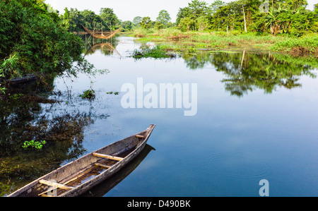 Bateau en bois qui fuit en lagon avec filet de pêche chinois sur l'île de Majuli, dans l'Assam, au nord-est de l'Inde. Banque D'Images